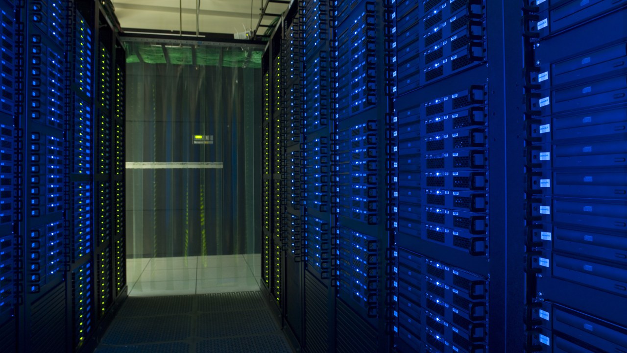Serverhall med blå ljus och rader av datorrack.